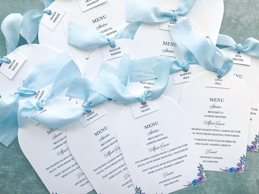 Die-cut wedding menus embellished with luxurious blue silk ribbon
