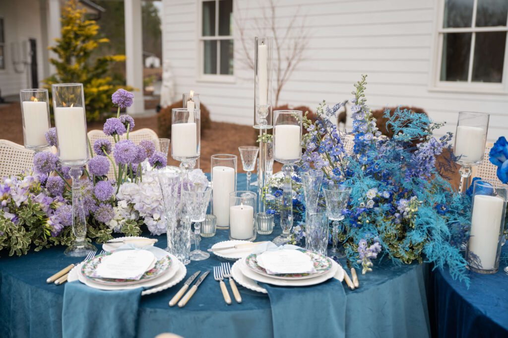 Outdoor wedding reception table with blue linens and florals
