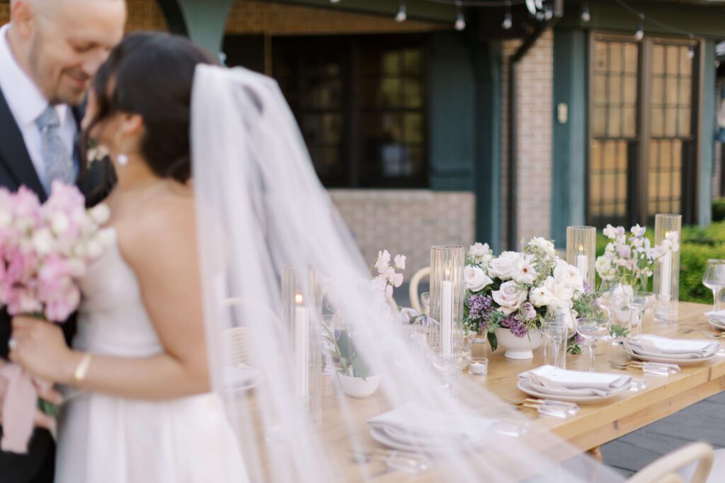 Bride and groom kissing at outdoor wedding reception