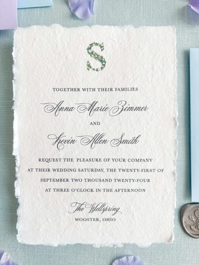 Whimsical handmade paper wedding invitation showing modern opening line