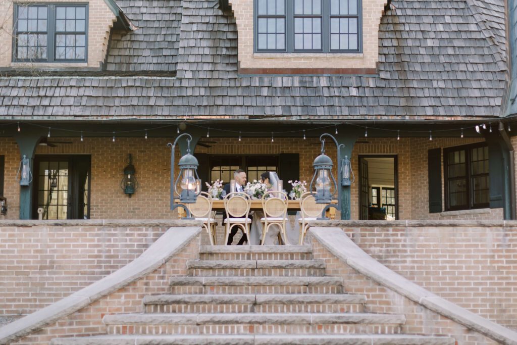 Bride and groom seated at outdoor wedding reception table