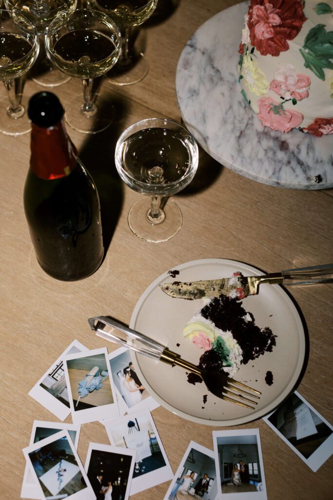 Post-reception flat lay featuring cake and Polaroids