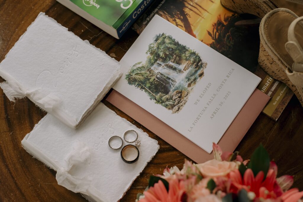 Vow books on handmade paper next to an elopement announcement for a Costa Rica wedding at La Fortuna Falls