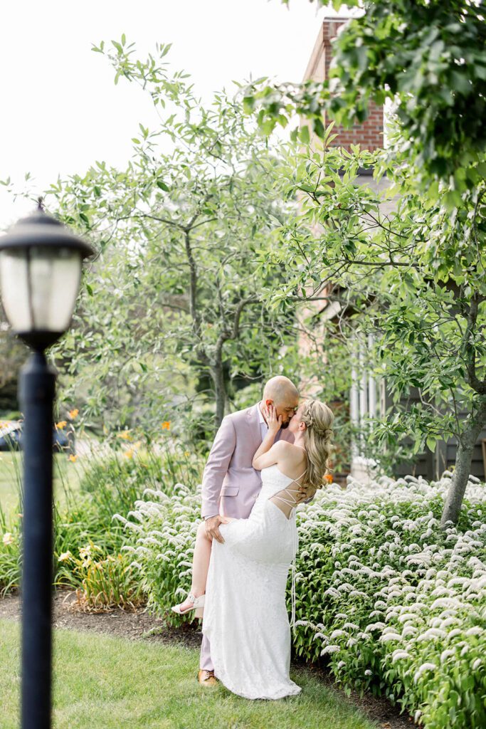 Bride and groom kiss in a garden in Chagrin Falls, Ohio