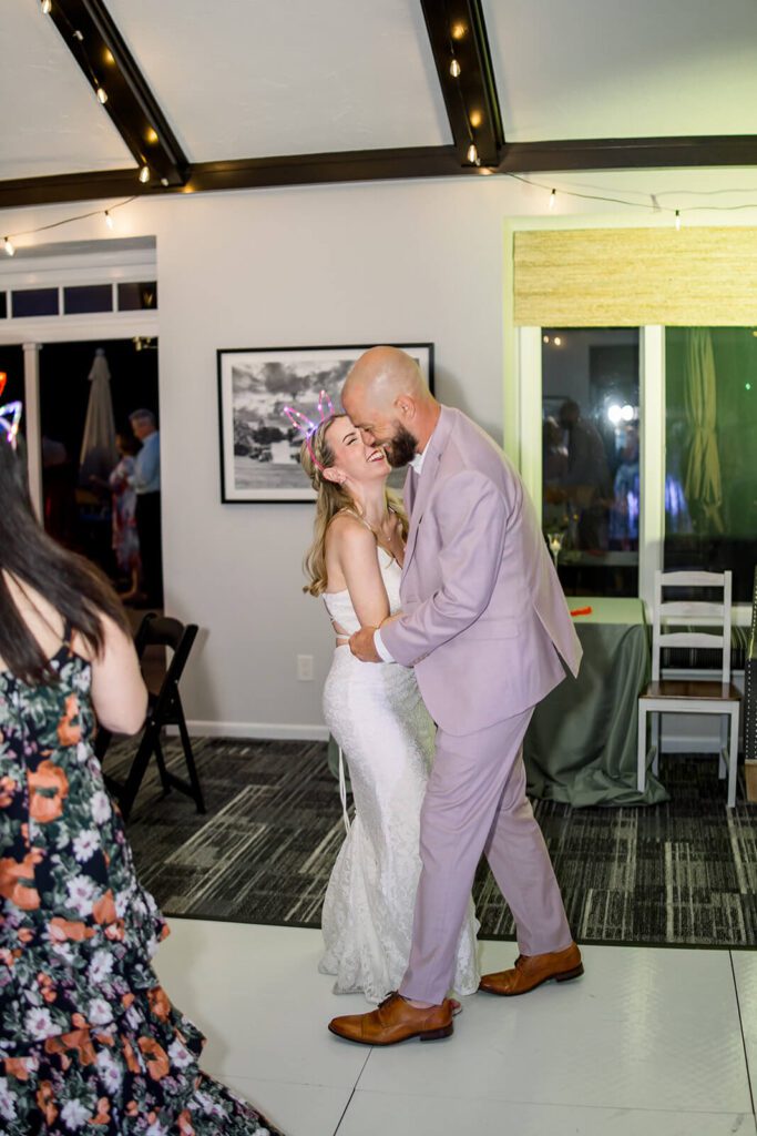 Bride and groom dance and laugh during their intimate wedding reception
