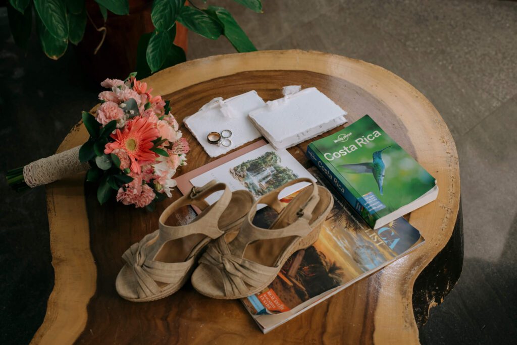 Details shot of a Costa Rica elopement, including bridal bouquet, Costa Rica guidebook, and elopement announcement card