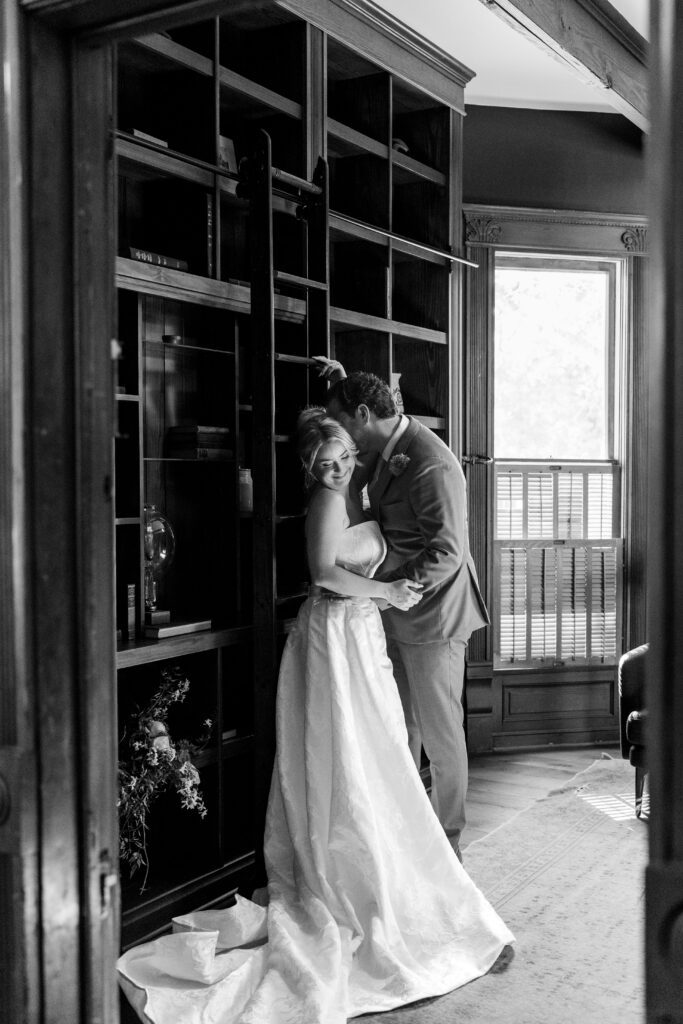 Moody candid of bride and groom kissing in a library