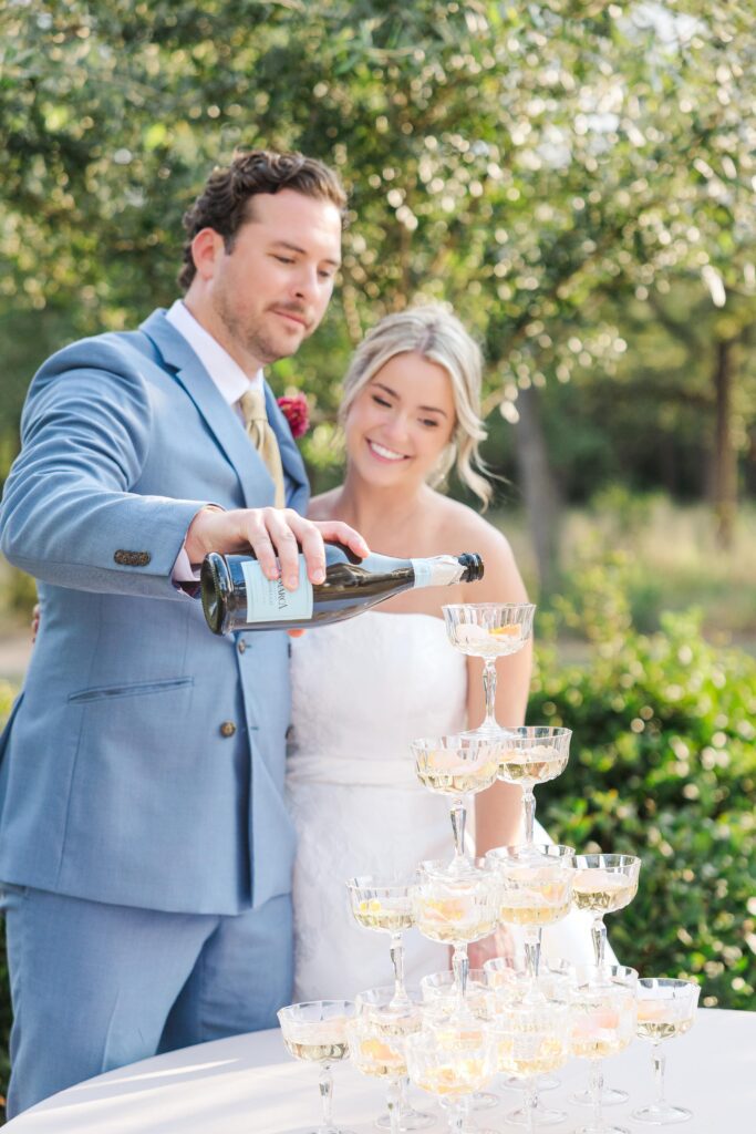 Groom pours champagne into a champagne tower