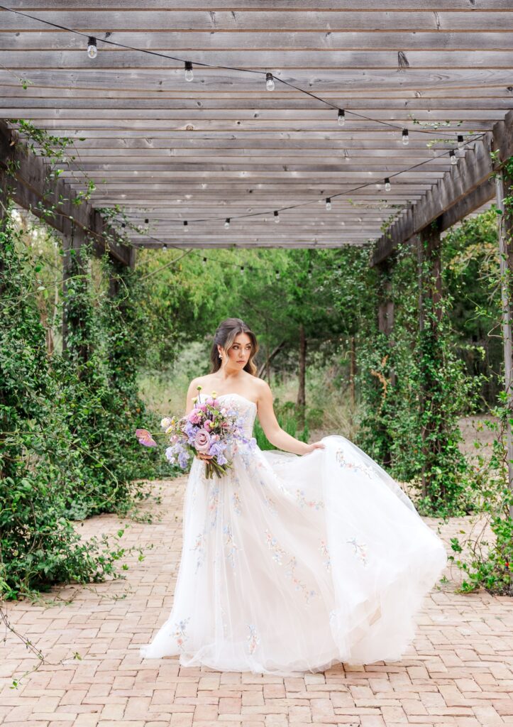 Bridal portrait under an arbor surrounded by greenery