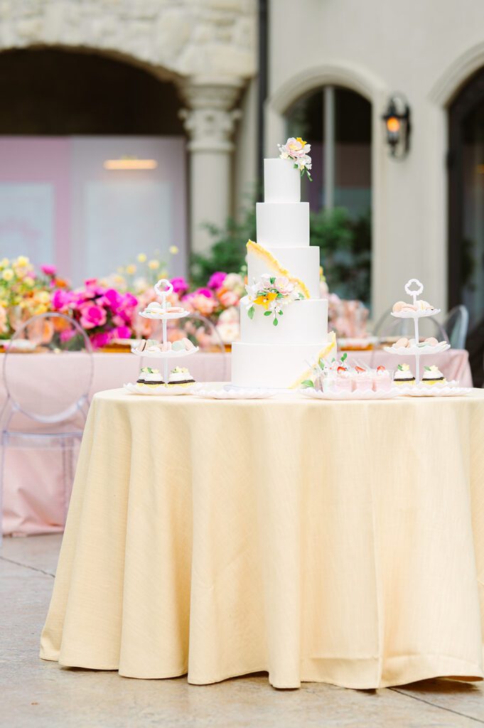 Wedding cake table with yellow tablecloth and five-tiered cake