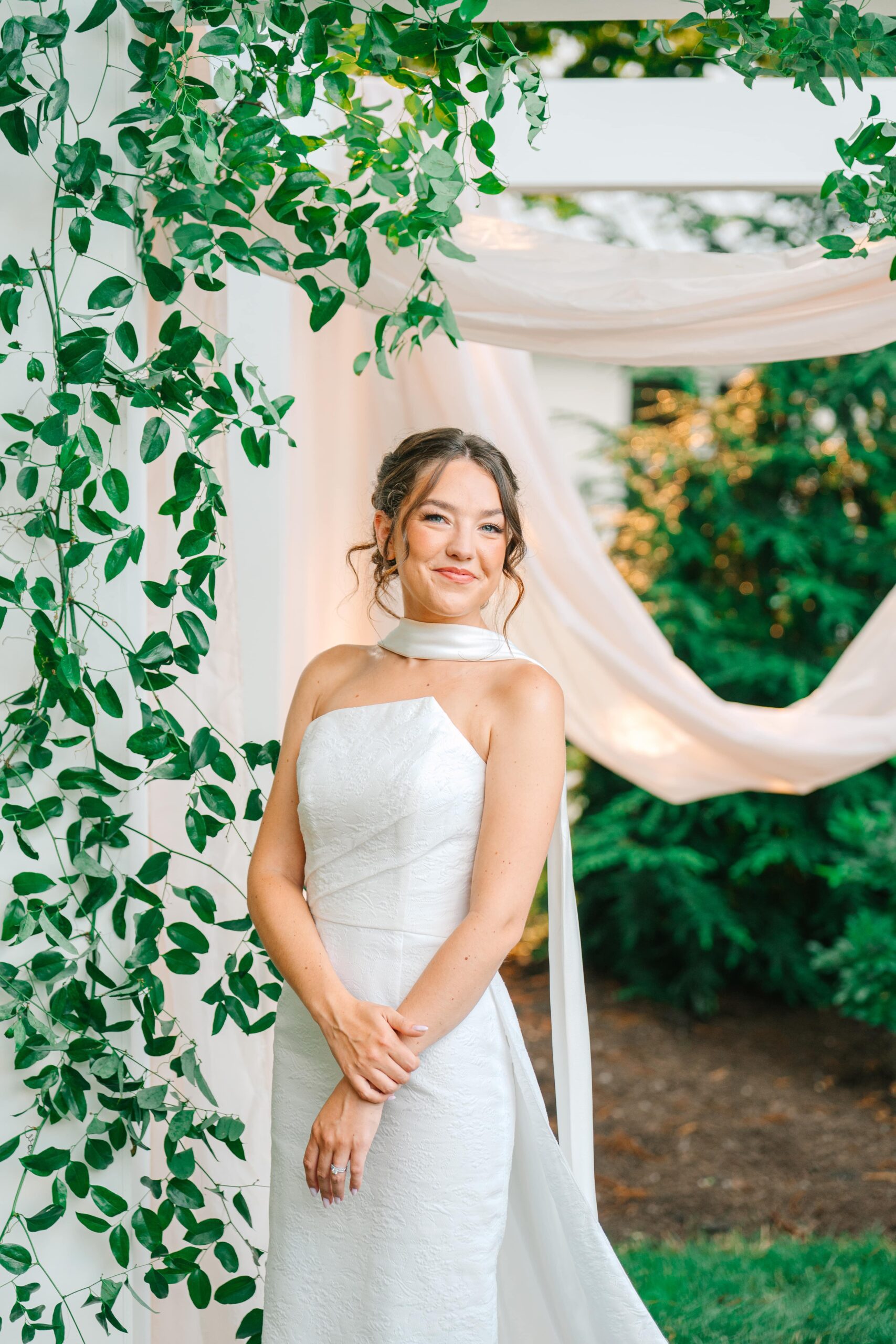 Elegant bridal portrait in garden surrounded by greenery and ivory draping