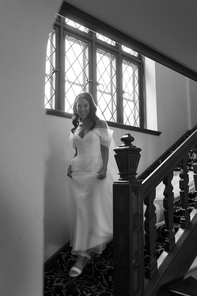 Bride descending the staircase of Tudor House the morning of her wedding