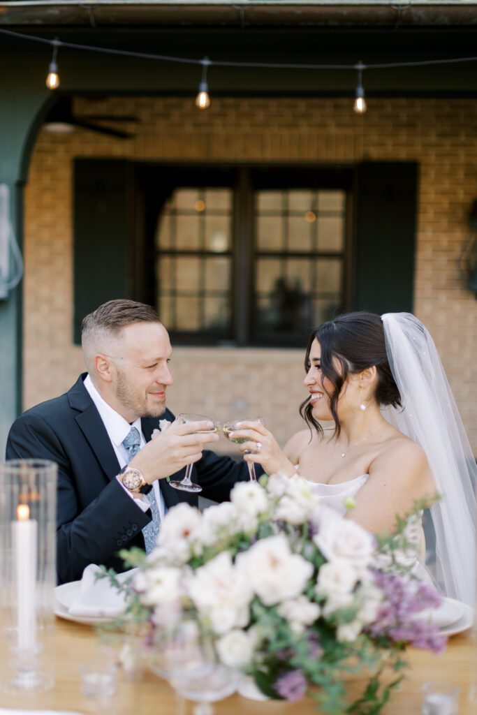 Bride and groom cheers drinks during their outdoor wedding reception at Basil Place