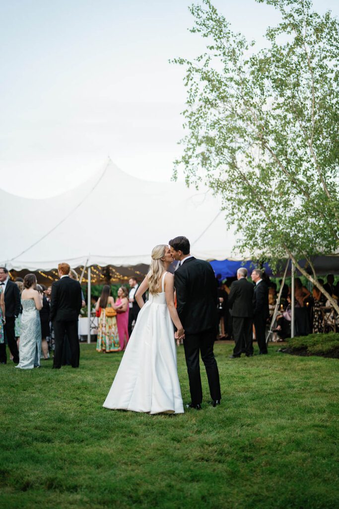 Bride and groom kiss outside their tented wedding reception at The Orchid House