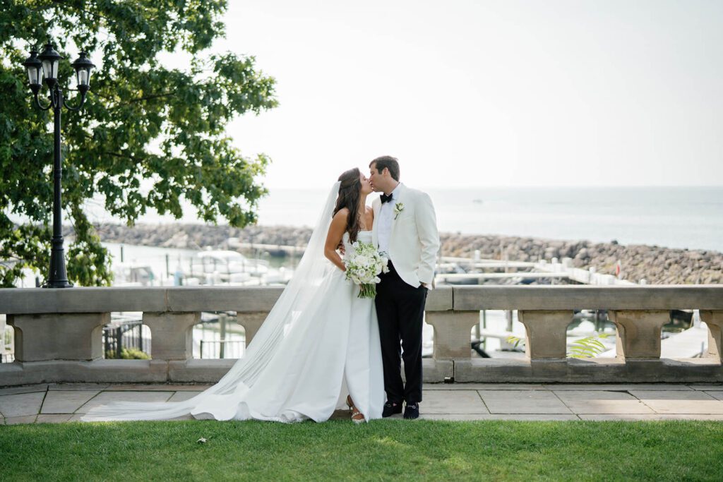 Bride and groom kiss along the coast at Shoreby Club