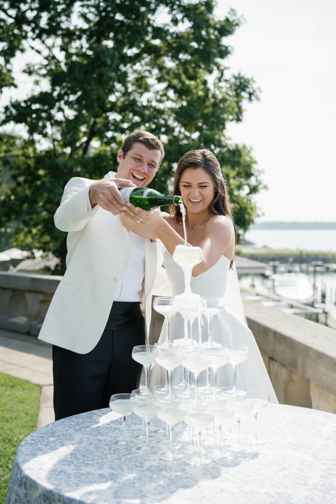 Bride and groom pour champagne into a tower as it overflows