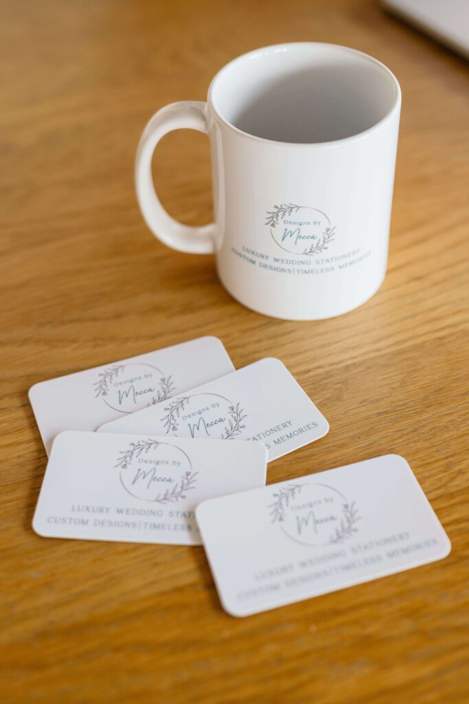 Mug and business cards featuring the Designs by Mecca logo