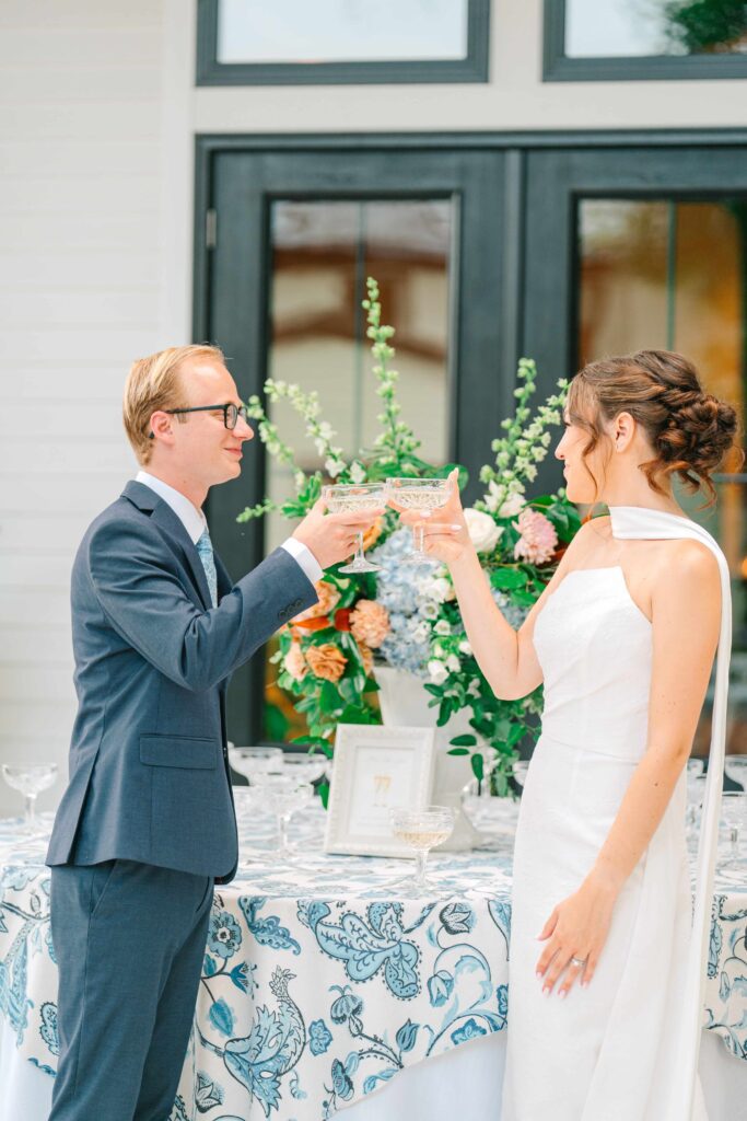 Bride and groom clinking champagne glasses at cocktail hour