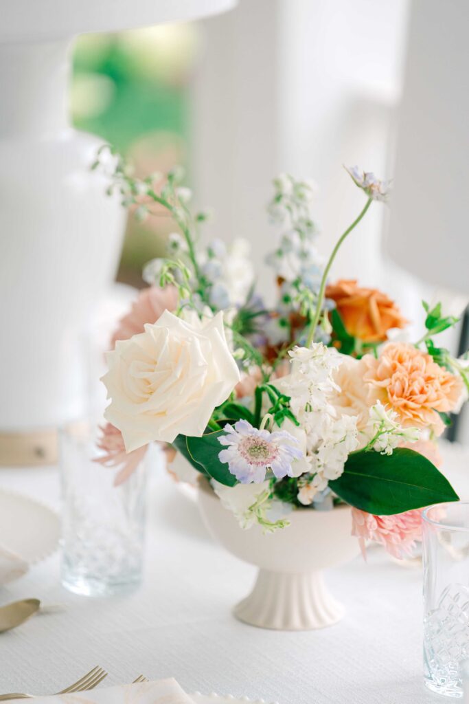 Elegant low floral display of creams, pinks, and peaches