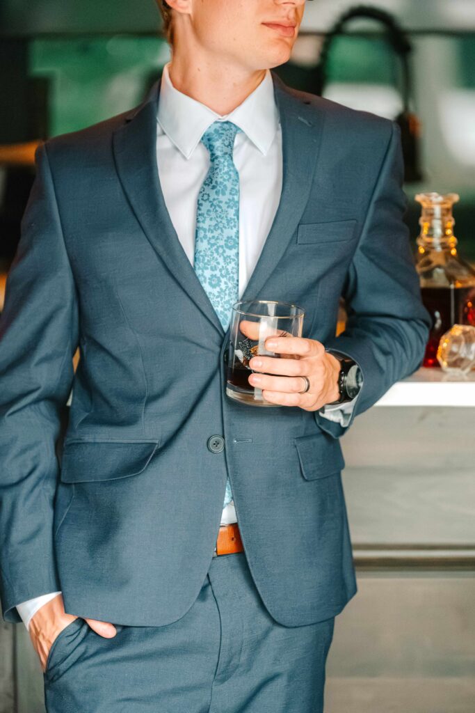 Groom holding bourbon glass in the bourbon lounge