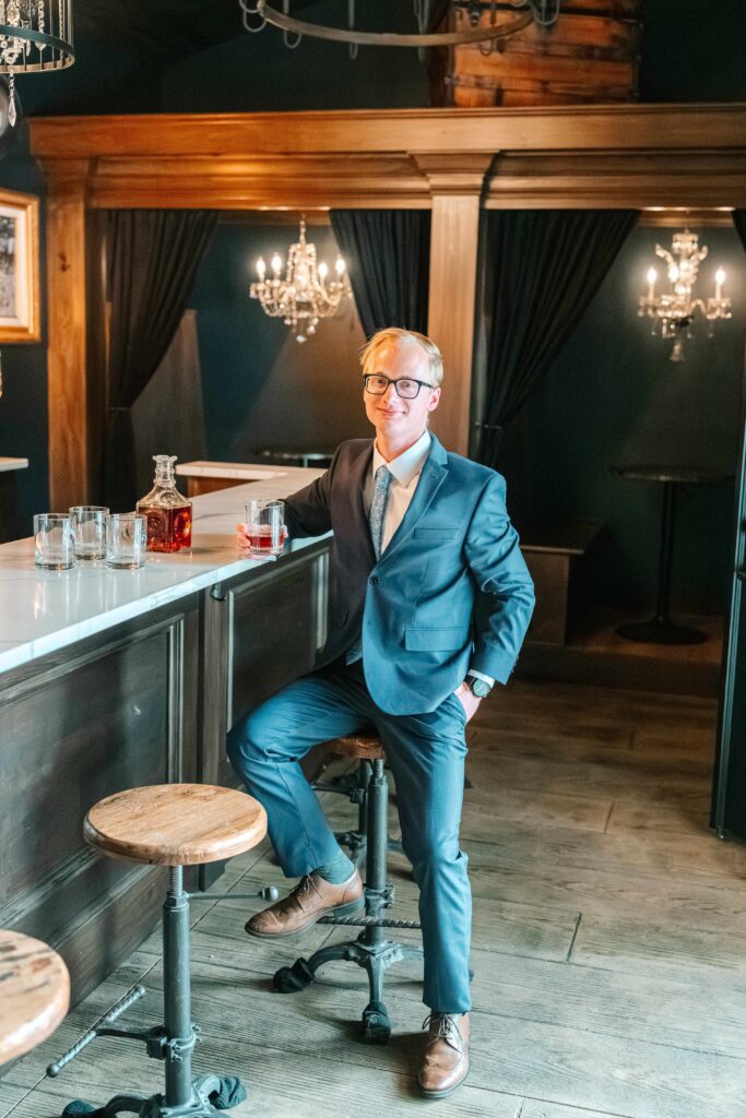 Portrait of the groom in the bourbon lounge at 1840 Manor House