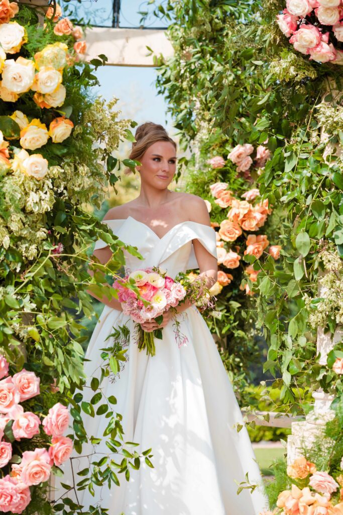 Portrait of bride with vibrant pink, orange, and yellow bouquet