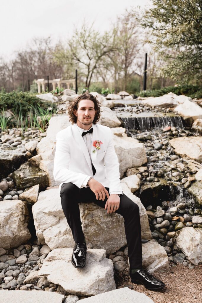 Portrait of groom in white tux at Knotting Hill Place