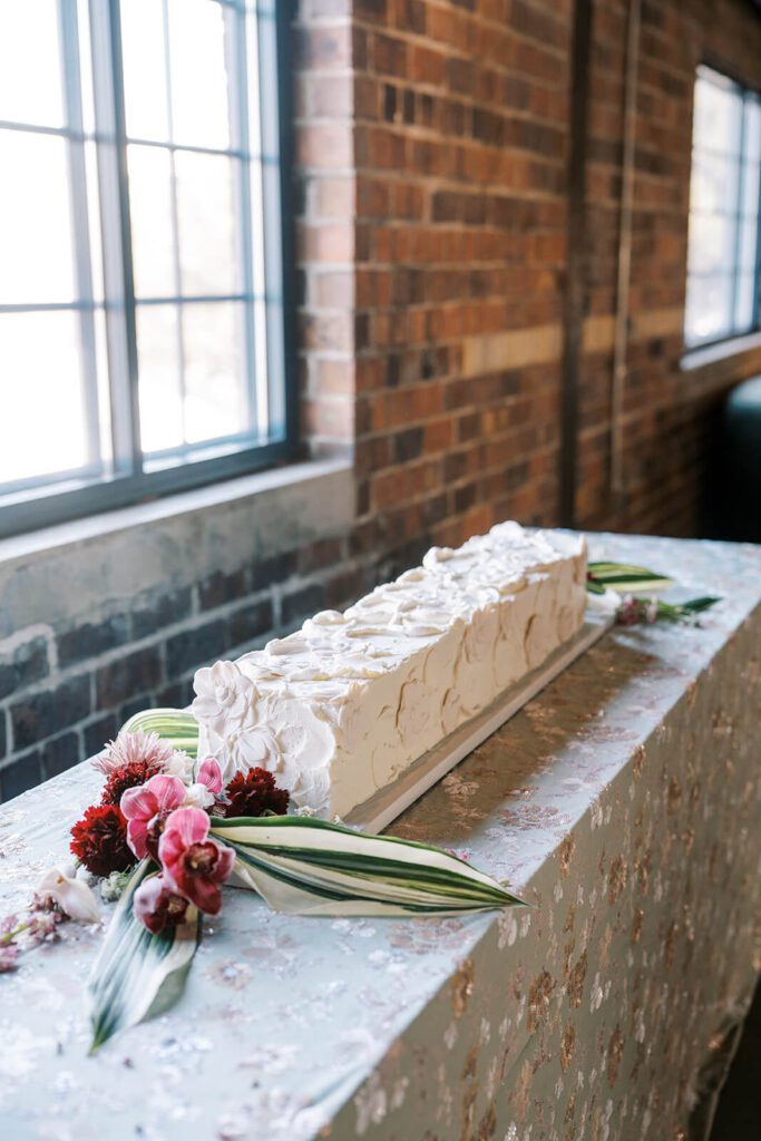 Long, white buttercream cake with floral details