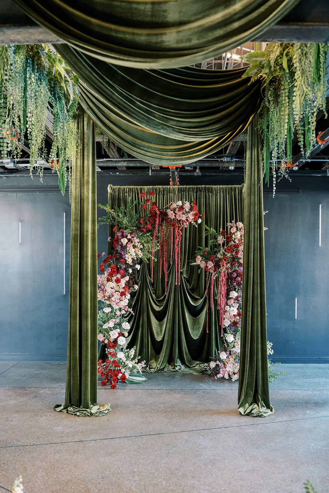 Dramatic green velvet draping and moody florals for a Post 4 wedding ceremony