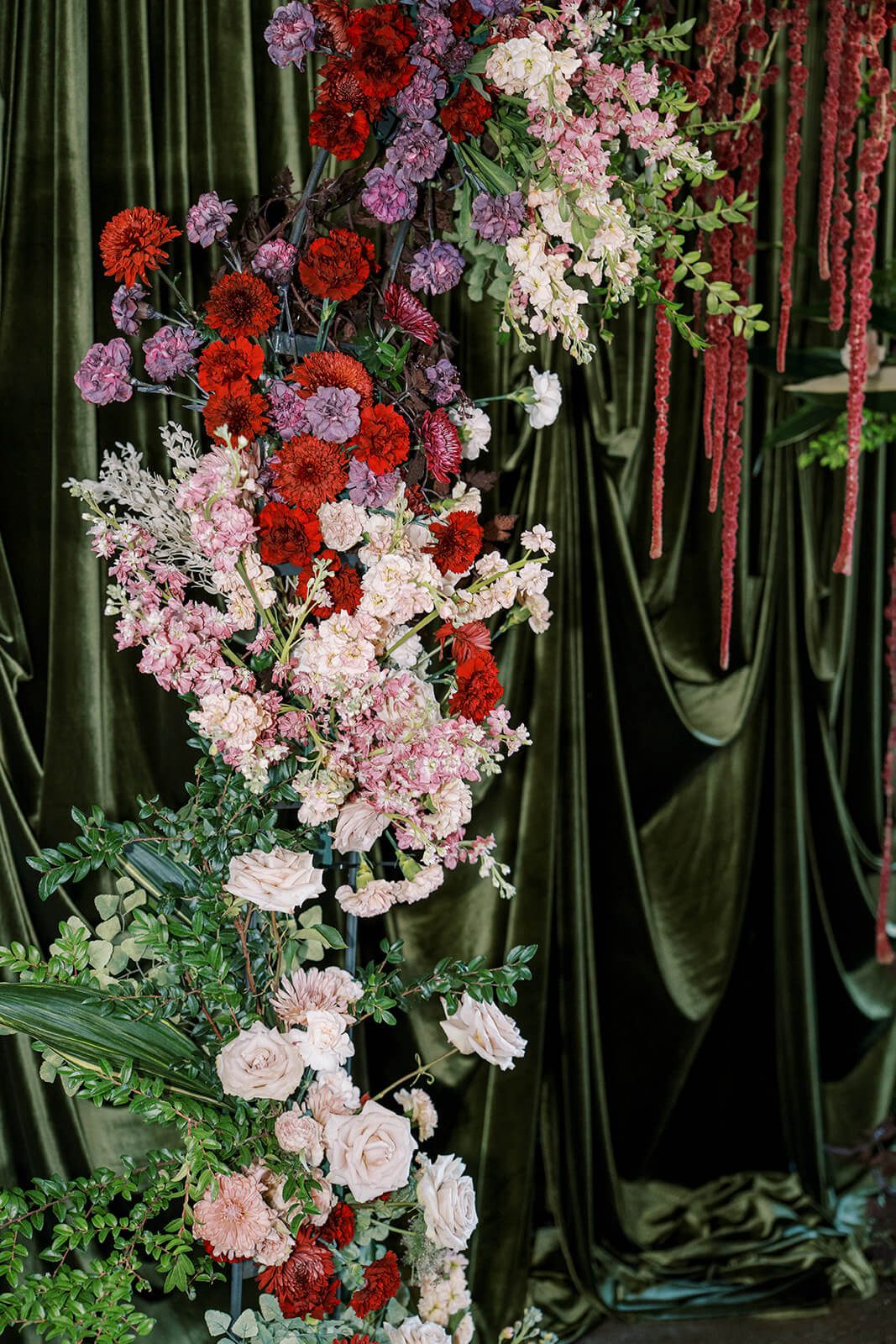 Floral arch in reds, purples, pinks, and greens