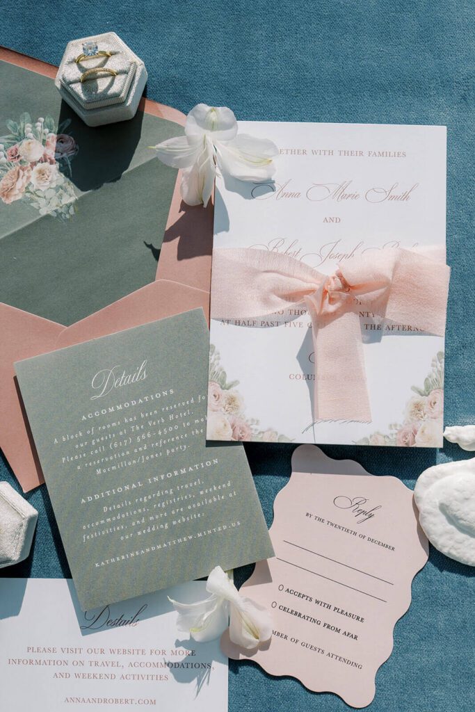 Romantic pink wedding invitations with silk ribbon and floral artwork