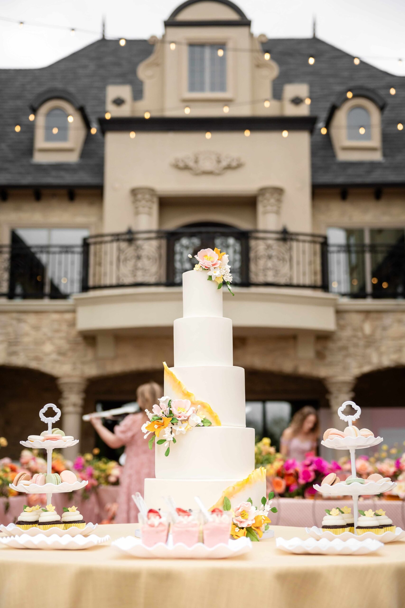 Five-tiered wedding cake and dessert table