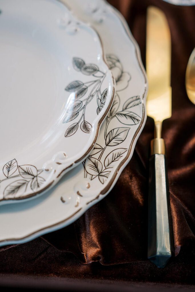 Vintage floral plates with gold flatware for a wedding reception at Brick and Mortar Columbus