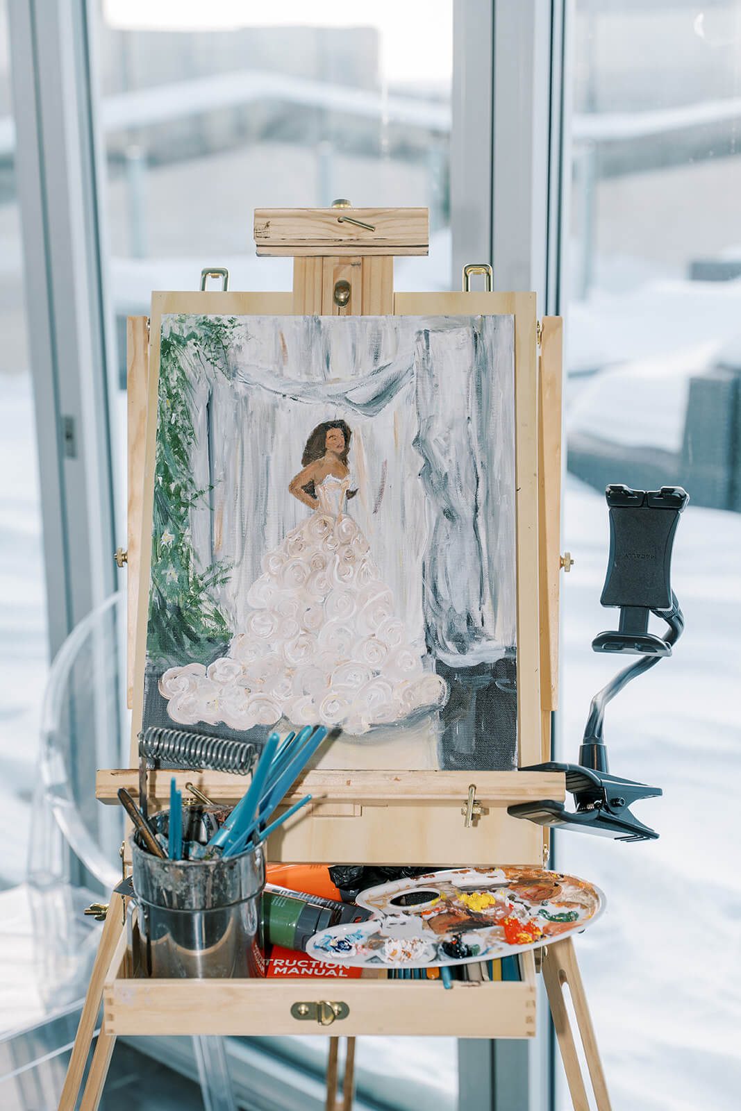 Live wedding painter's finished canvas showing a portrait of the bride