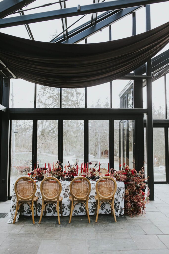 Wedding reception table under black draping in the Glasshouse at Cedar Lakes Estate