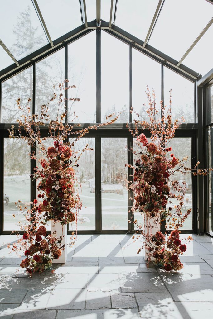 Dramatic red floral columns for a wedding at Cedar Lakes Estate