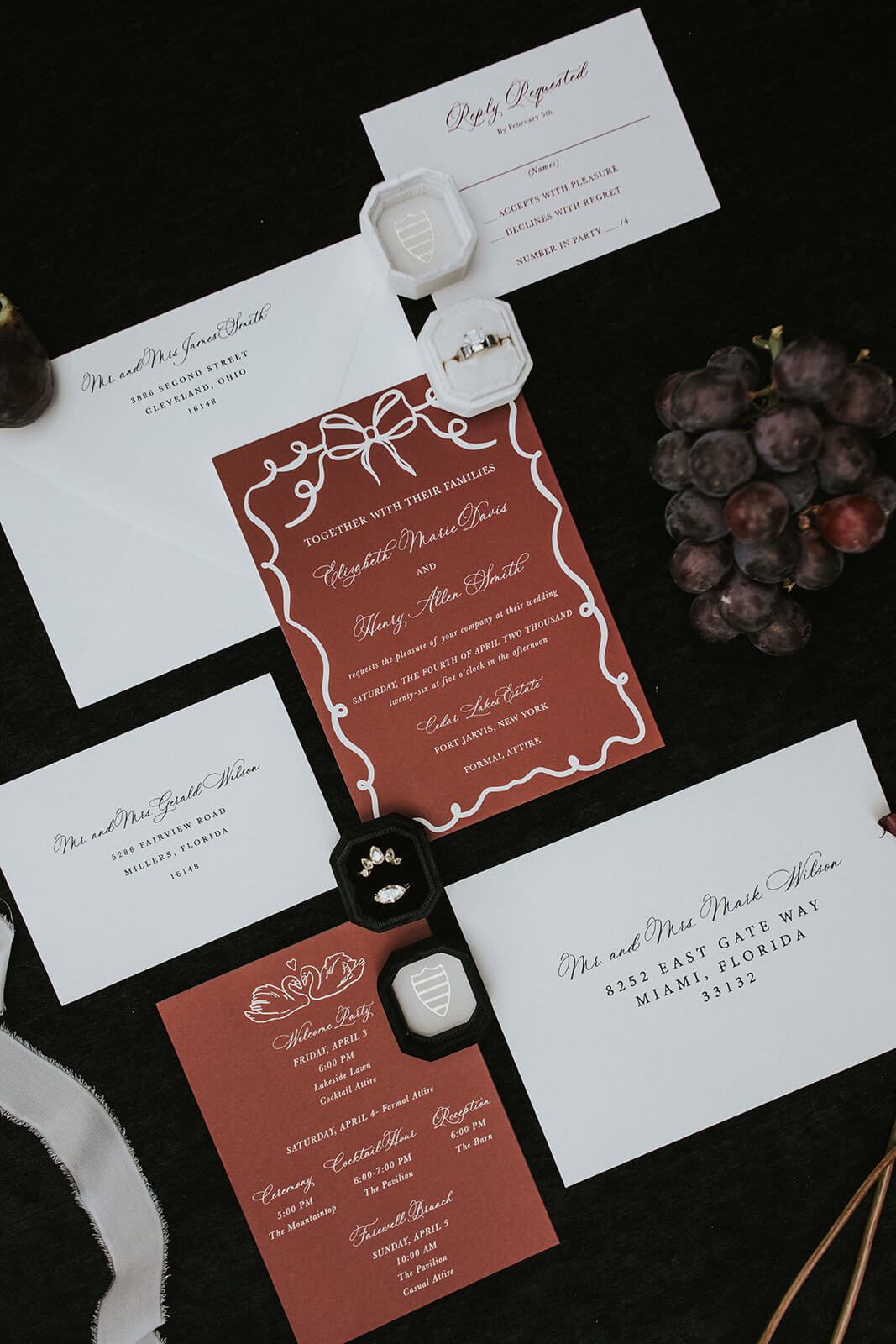 Deep terracotta wedding invitation suite with illustrated bow and swan details
