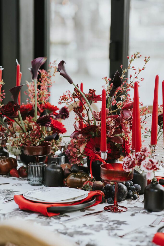 Cedar Lakes Estate wedding reception tablescape in shades of red, with taper candles and floral arrangements