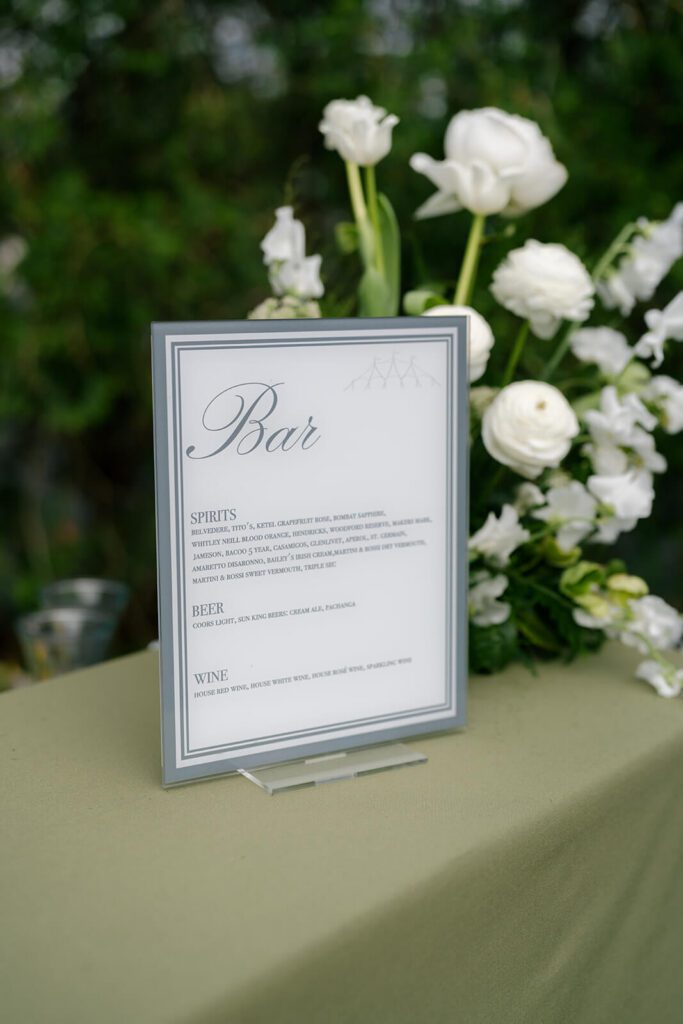 Classic bar sign on a green tablecloth surrounded by white flowers