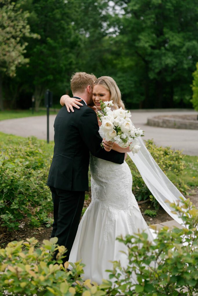 Bride and groom hug after an emotional first look on their wedding day