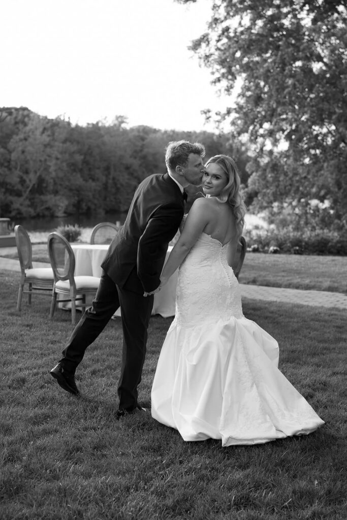 Portrait of the groom kissing the bride by the lake at The Montage Indianapolis