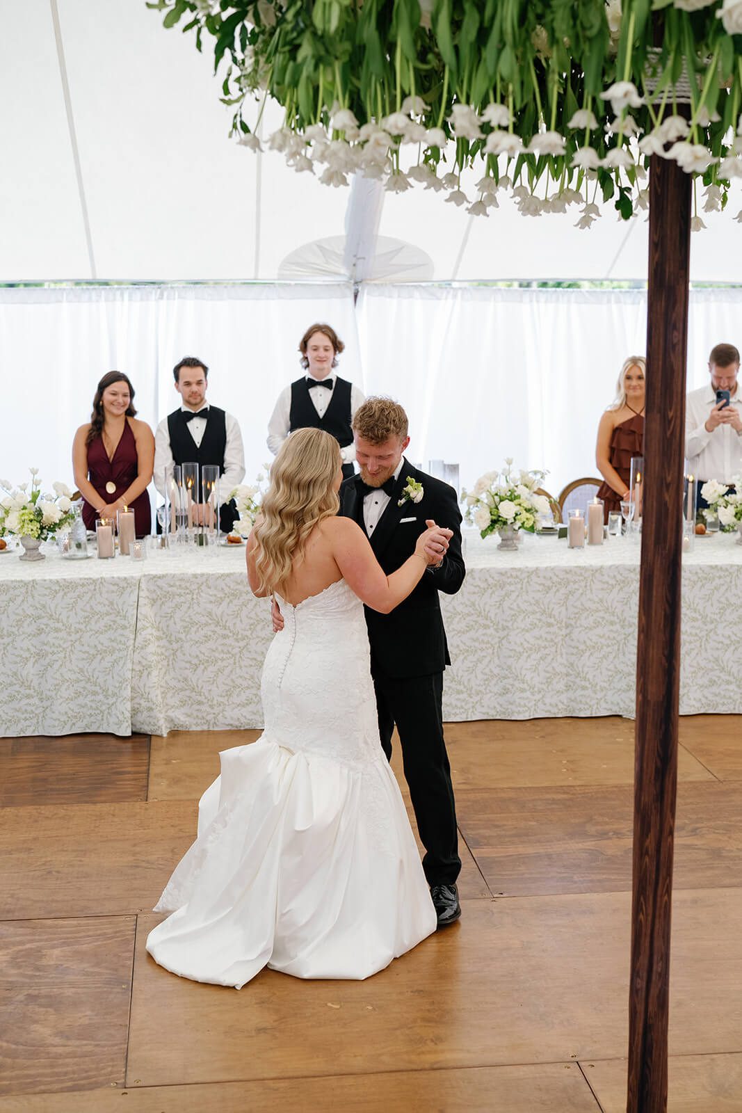 Bride and groom slow dancing for their first dance as guests watch