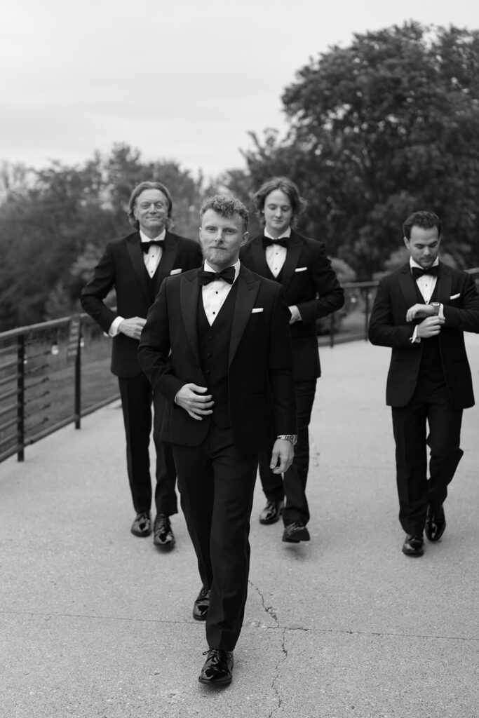 Groom walking with groomsmen on his wedding day