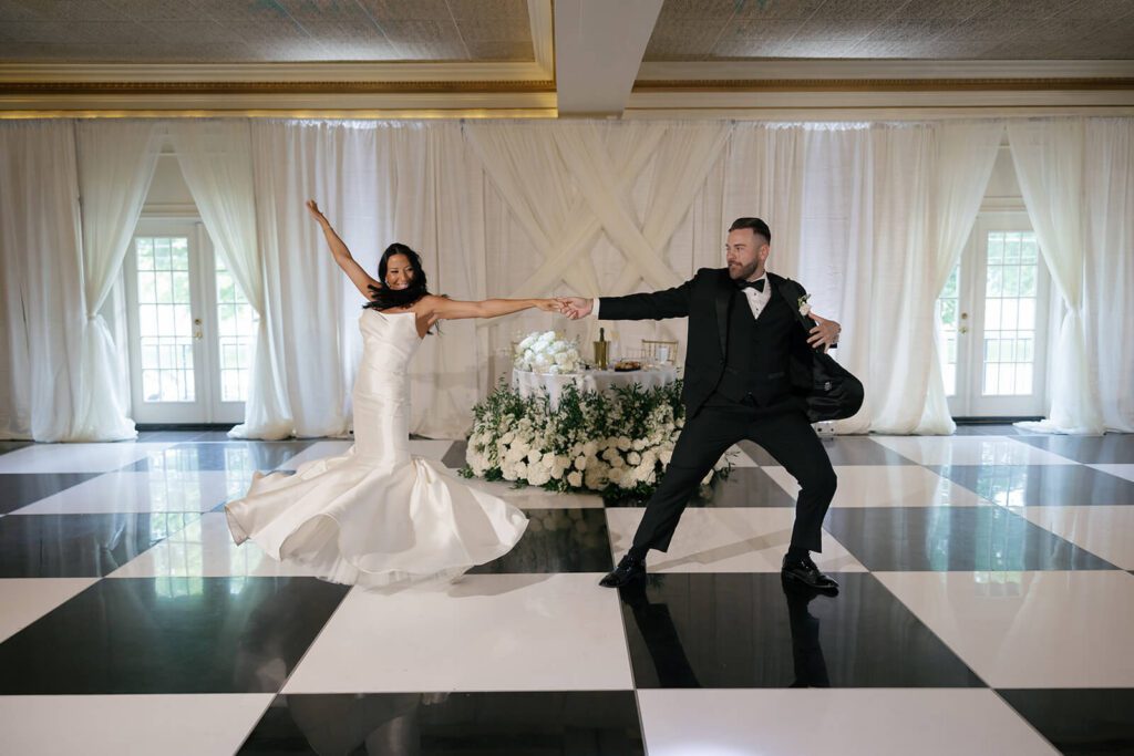 Bride and groom doing their first dance on a black and white checkered floor in The Grand Ballroom