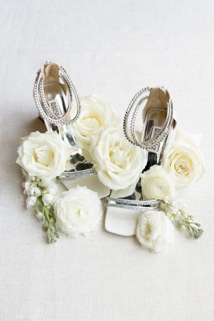 Flat lay of bride's shoes and white roses