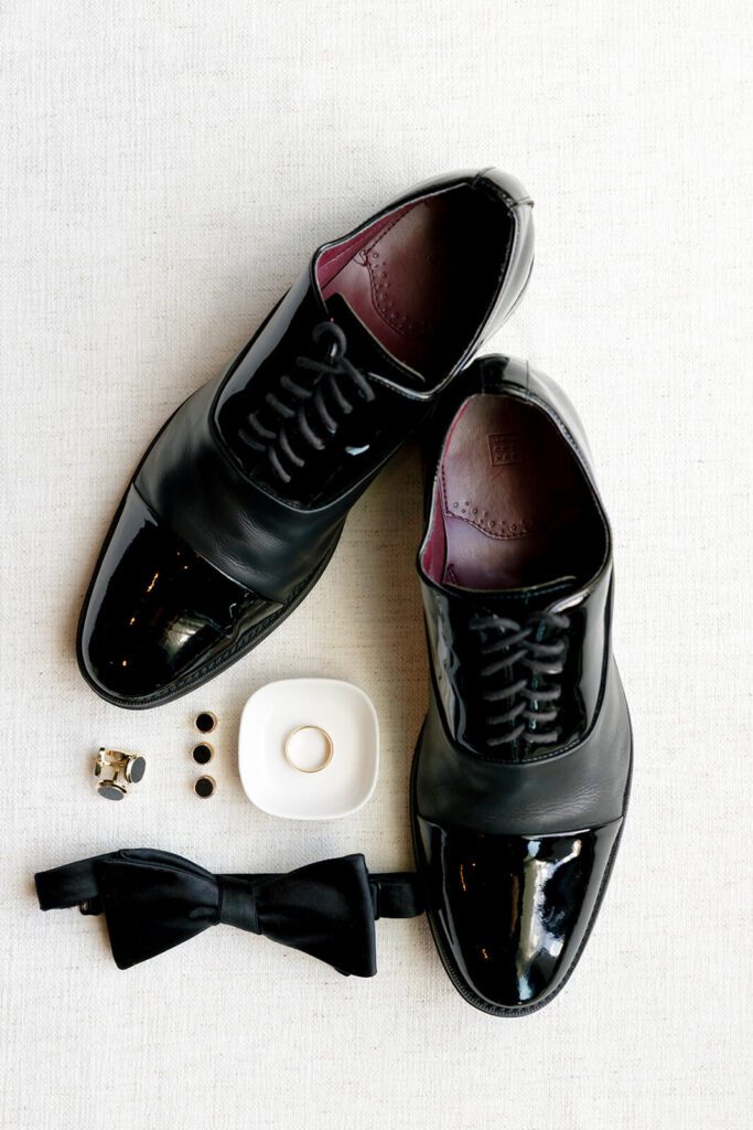 Flat lay of groom's wedding day items, like shoes and cuff links