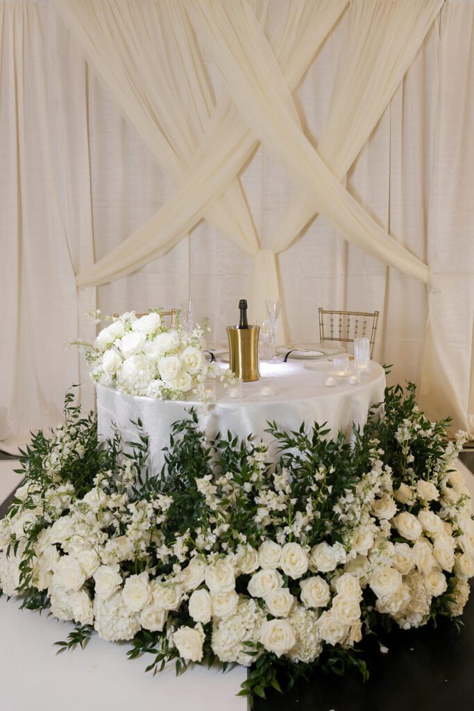 Timeless white and green floral arrangements around the sweetheart table