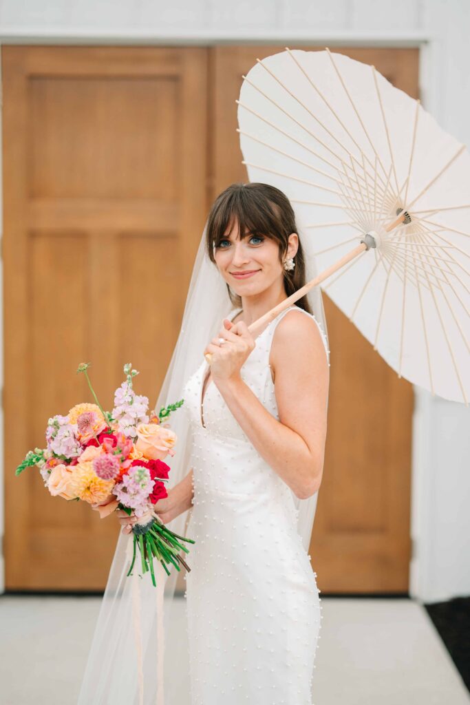 Bride outside with a parasol at The Wellspring on her wedding day
