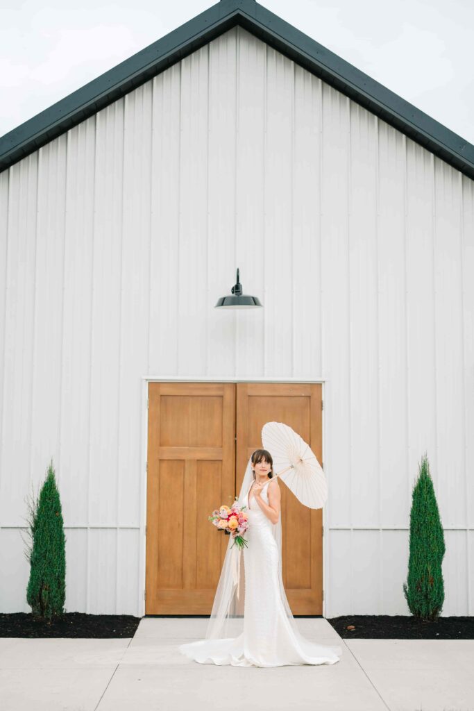 Bride outside with a parasol at The Wellspring on her wedding day
