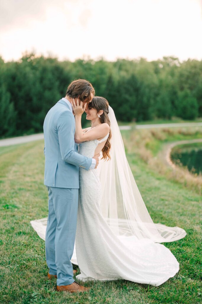 Couple embracing by the pond at The Wellspring on their wedding day